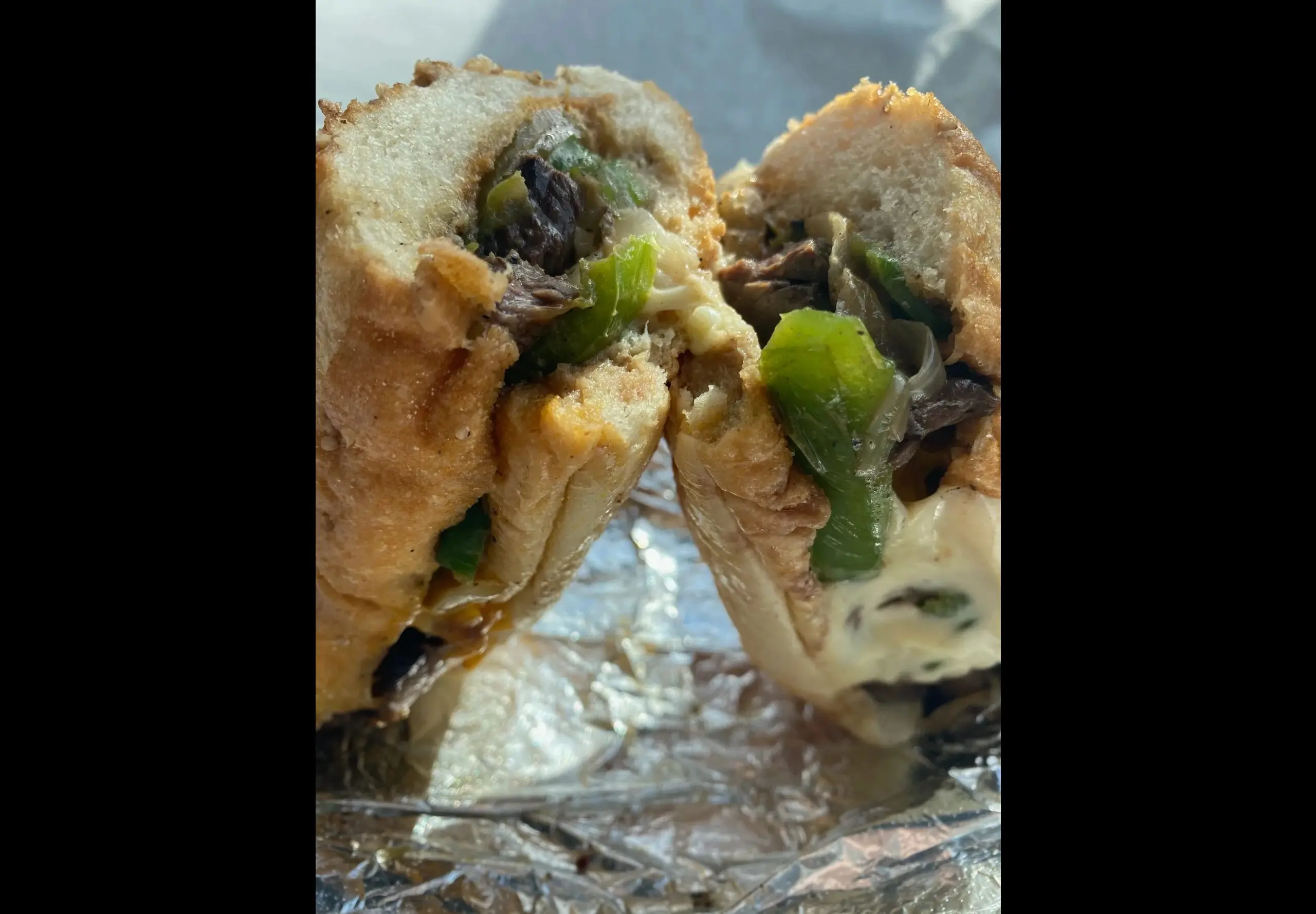 Philly cheesesteak sandwich with peppers and cheese.