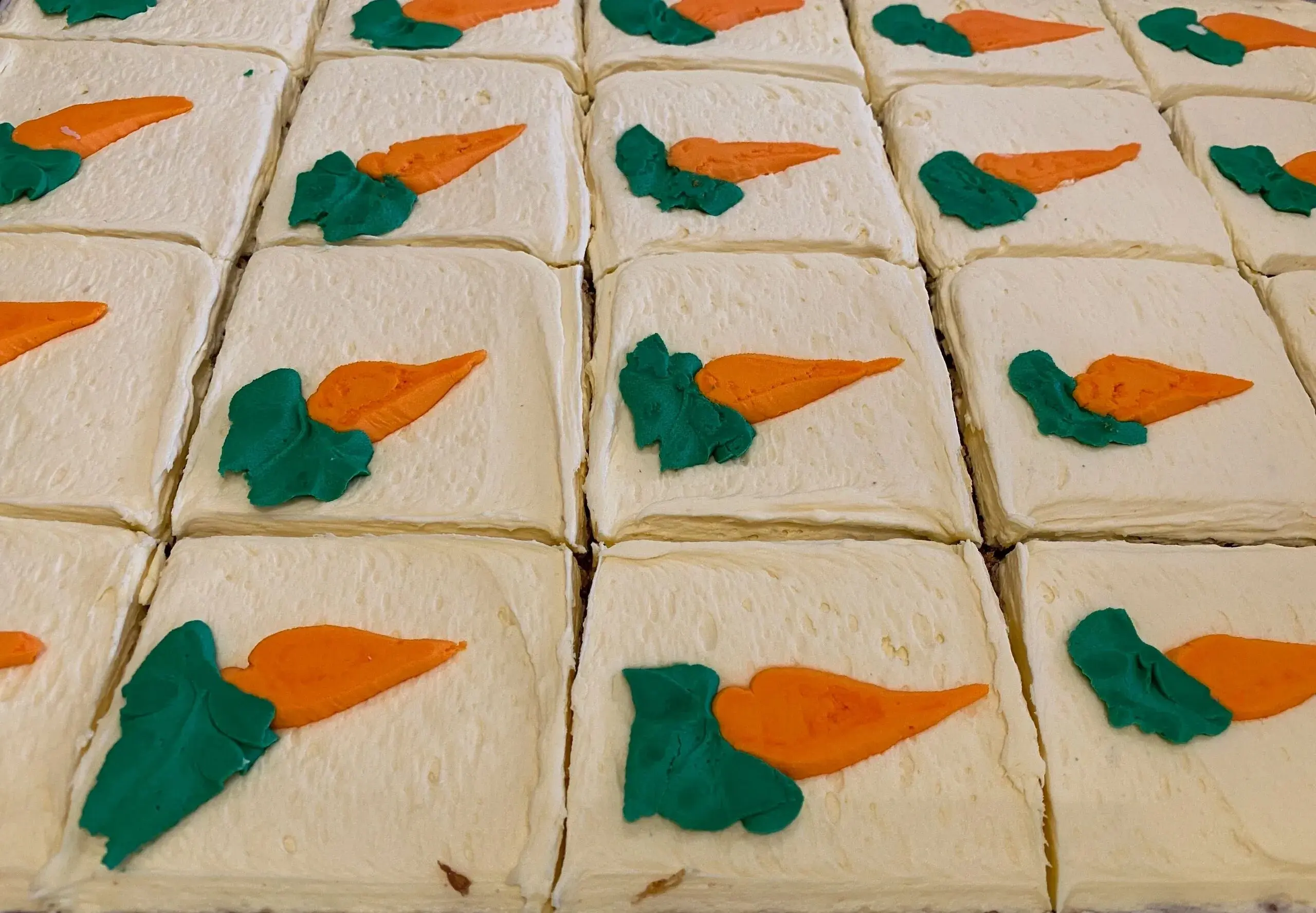 Carrot cake squares with frosting decoration.