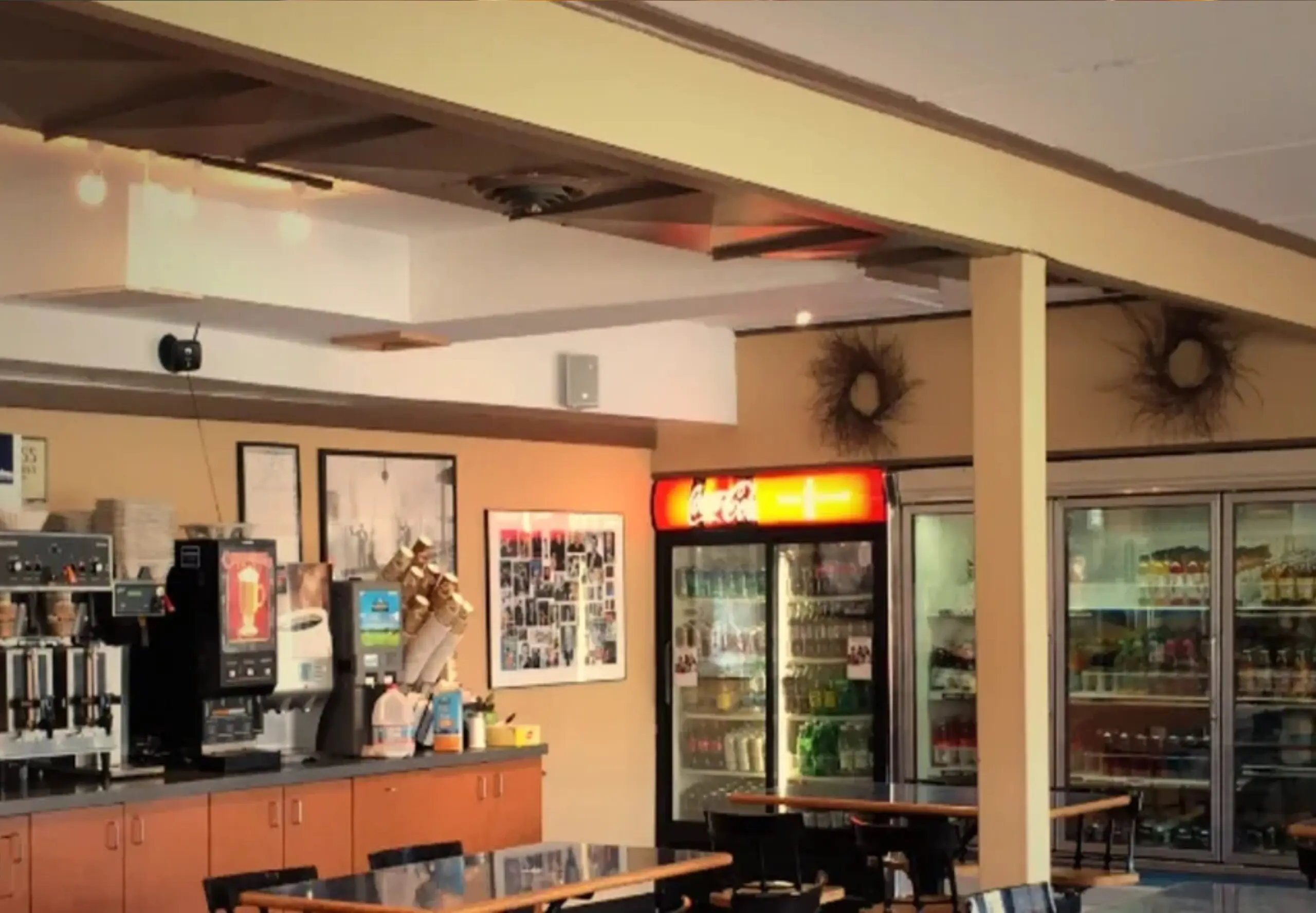 Cafe interior with tables and beverage machines.
