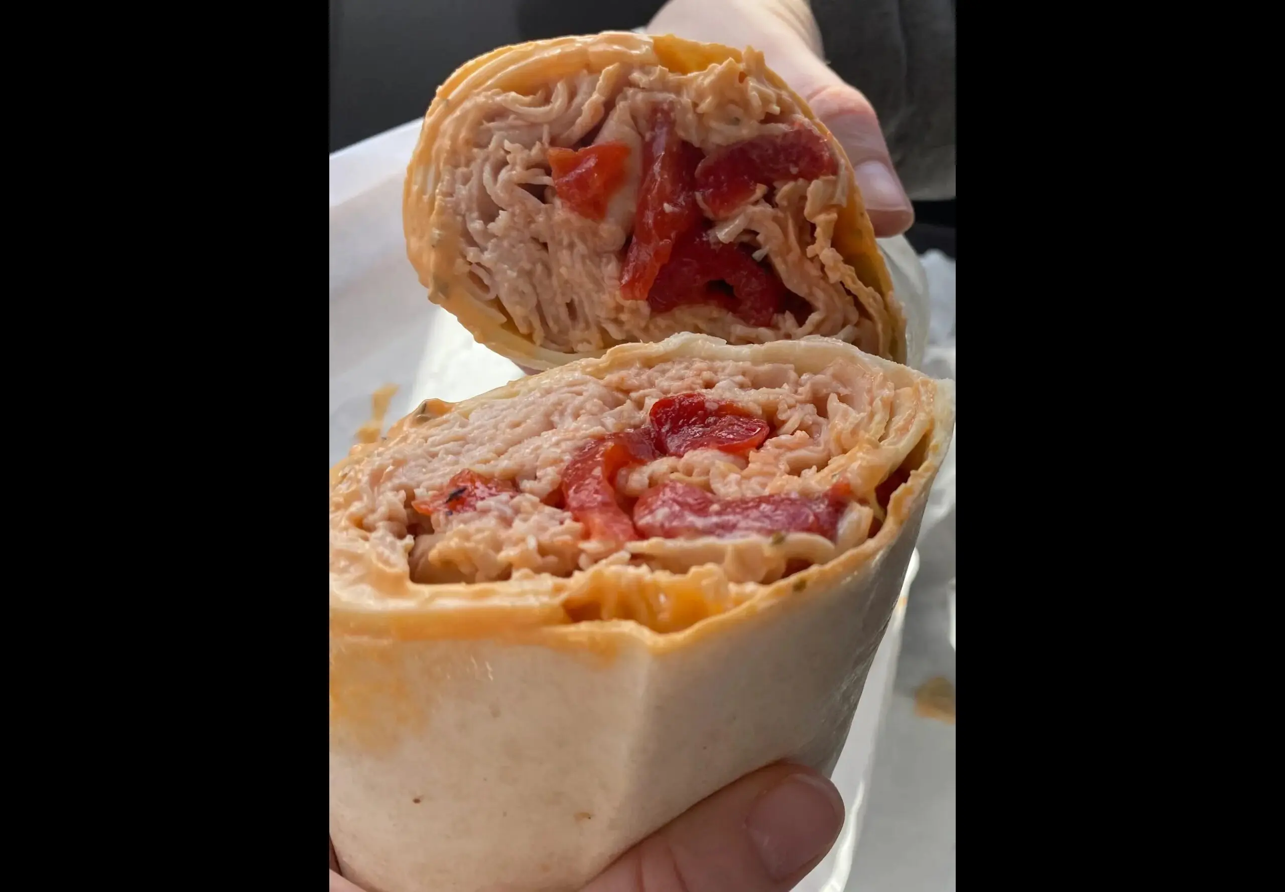 Sliced wrap with turkey and red peppers.