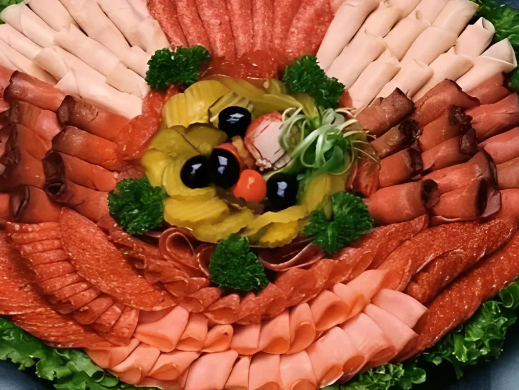 Deli meat platter with olives and garnish.