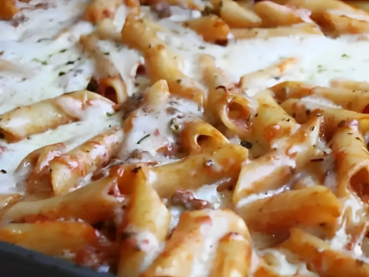 Baked ziti pasta with melted cheese topping.