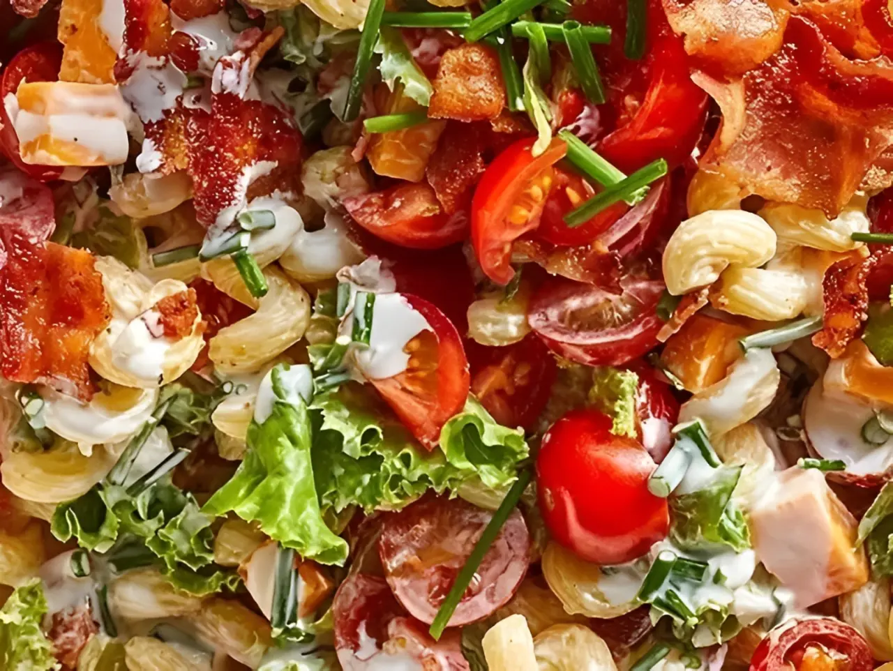 Pasta salad with bacon, tomatoes, and chives.